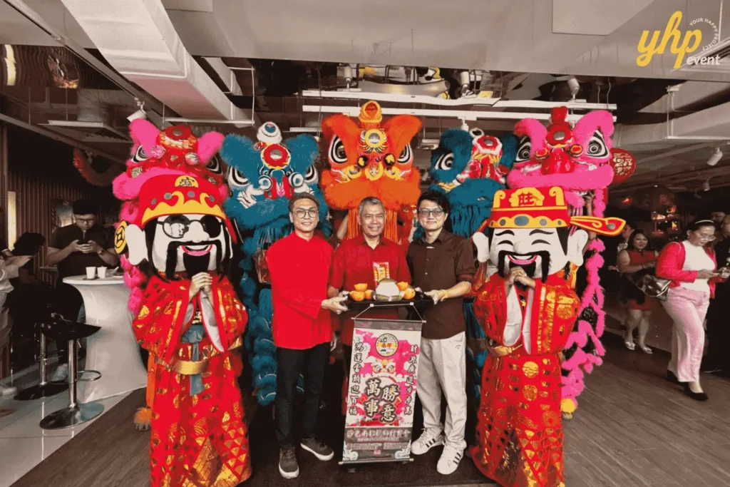Three guests pose with lion dance costumes and God of Prosperity mascots in SP Setia Sales Gallery 