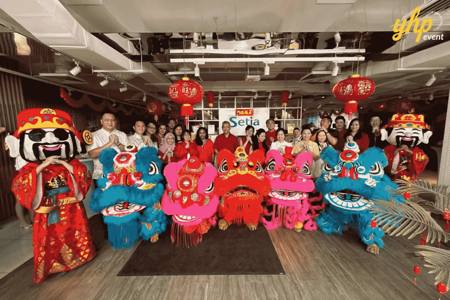 Lion dance performers and God of Prosperity mascots pose with a guest