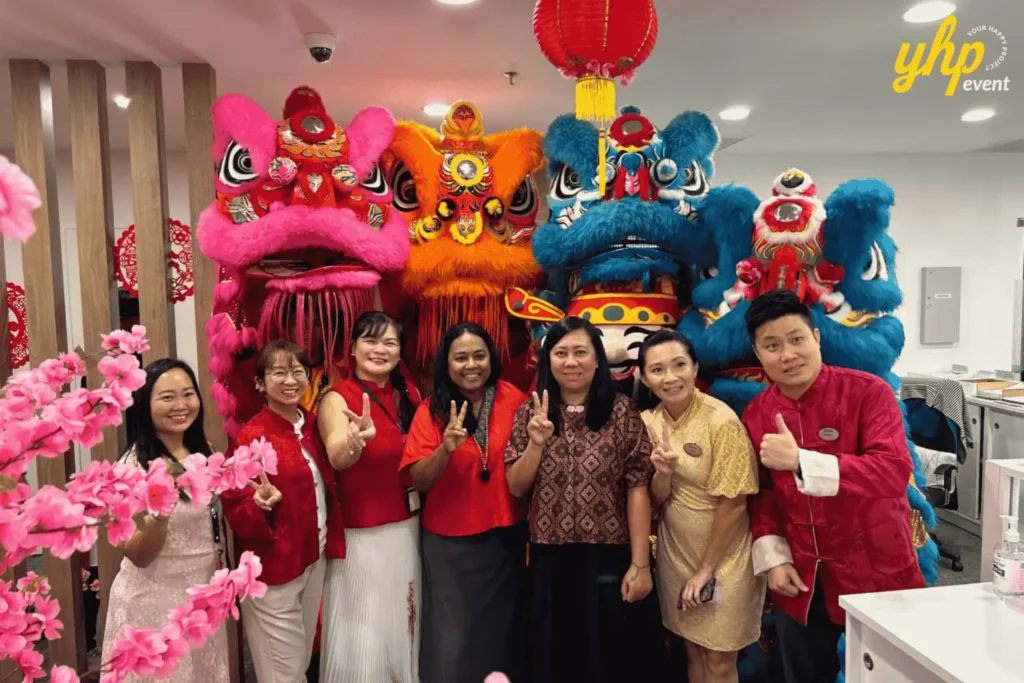Lion dance performers and God of Prosperity mascots pose with a guest