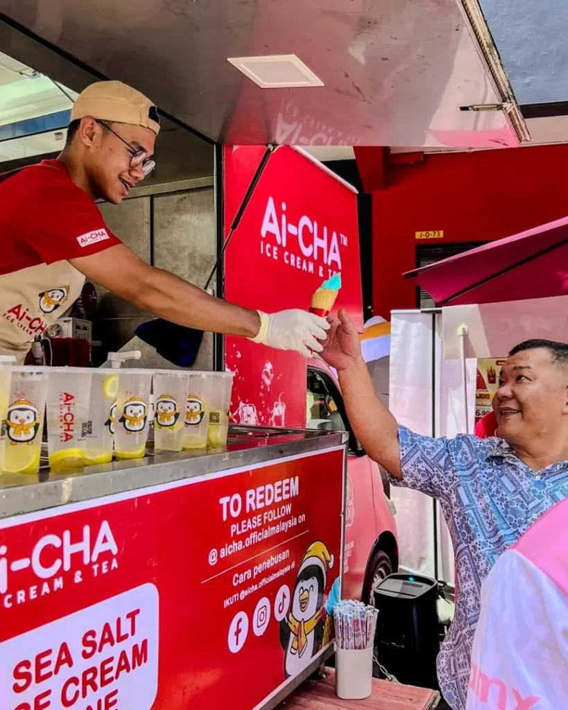 Celebrating Ai Cha’s “Love You 300x” Campaign – Brewing Across Sabah! 2 Customer receives an ice cream cone from Ai-CHA staff