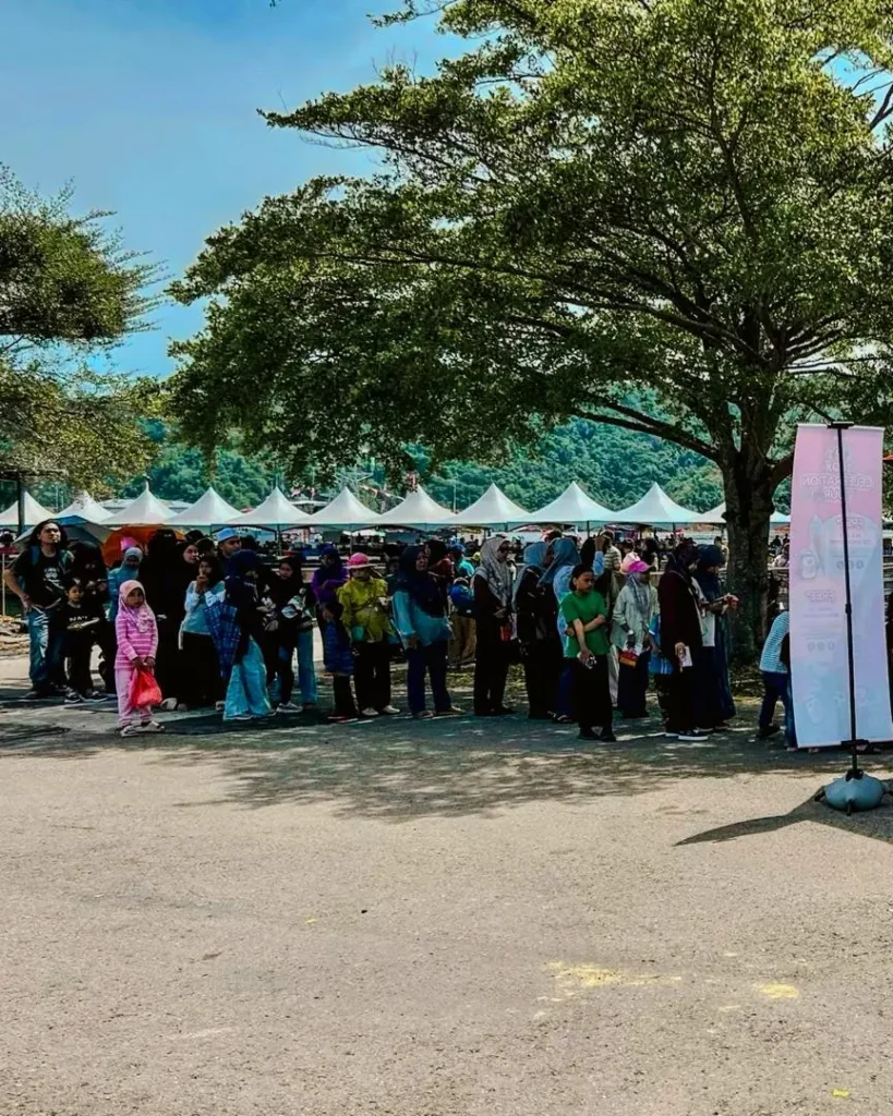Celebrating Ai Cha’s “Love You 300x” Campaign – Brewing Across Sabah! 3 Crowd lines up beneath large trees near the Ai-CHA booth during a busy outdoor community event