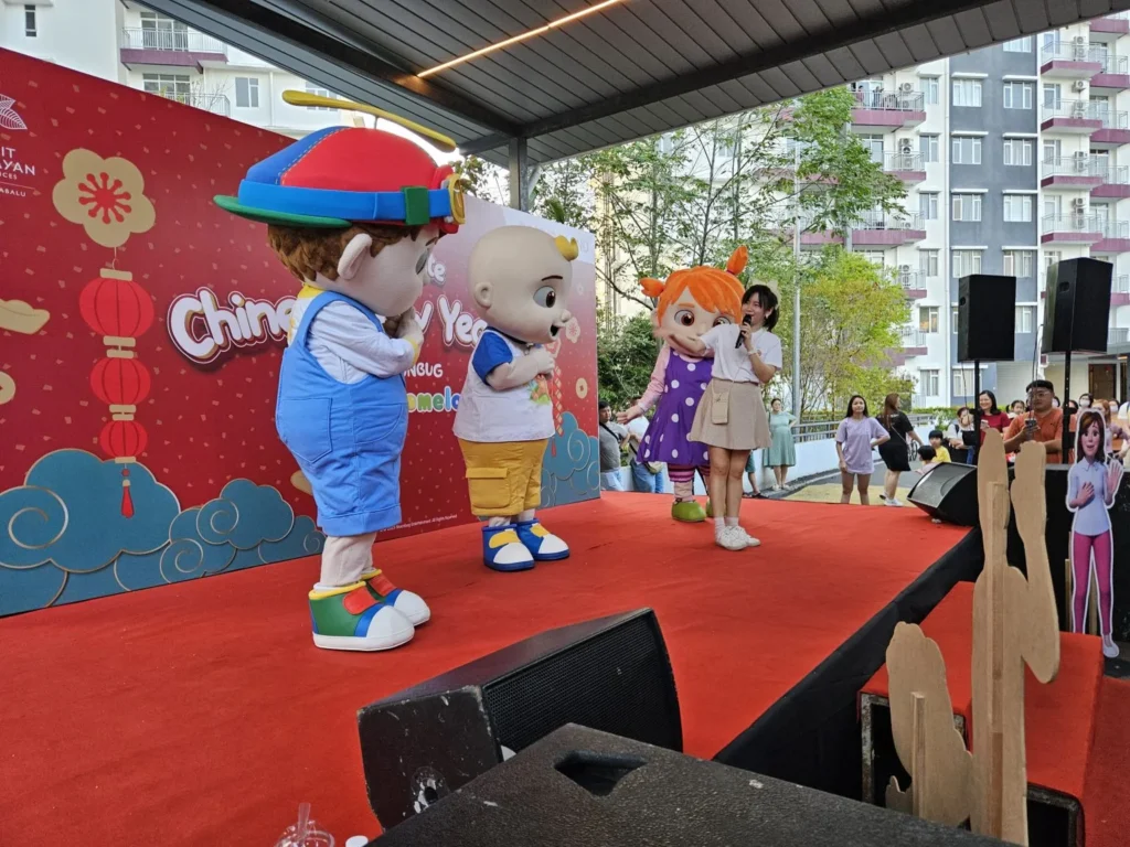 CoComelon mascot JJ performing on a red stage at a Gamuda Land Chinese New Year event