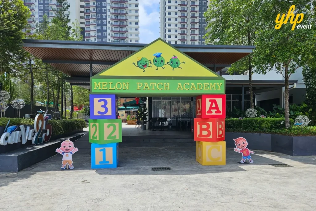The Melon Patch Academy entrance arch made of colorful alphabet blocks at a CoComelon themed event