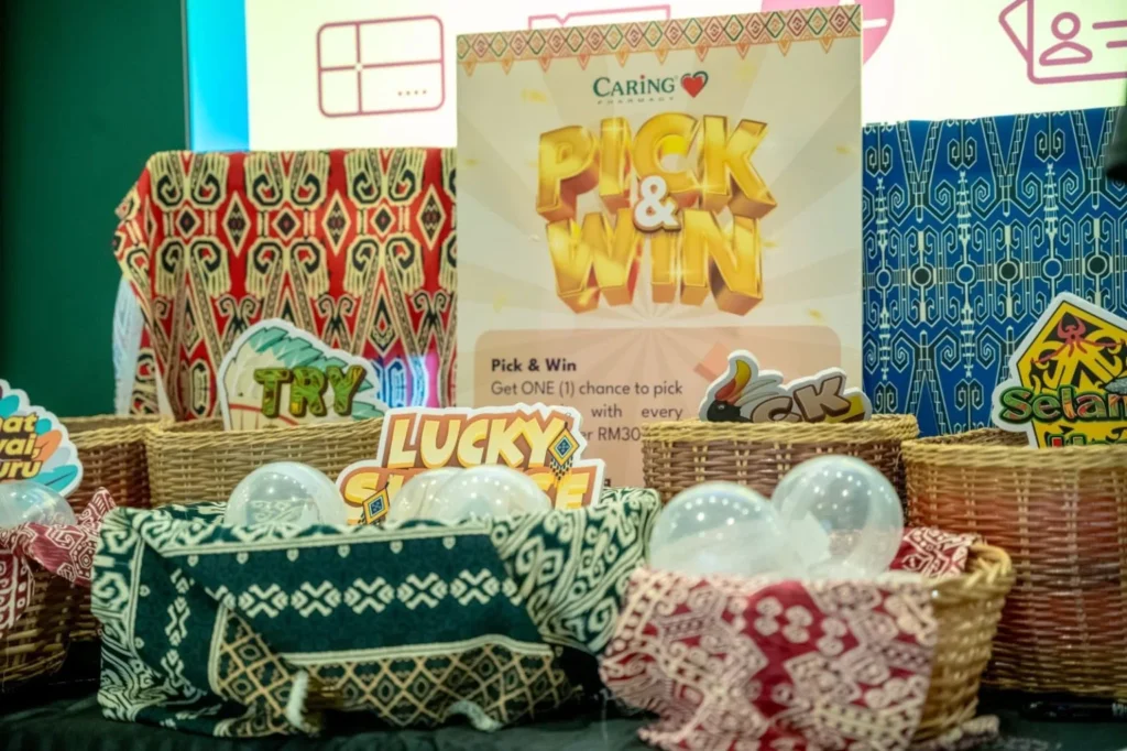 Caring Pharmacy Kaamatan & Gawai Campaign Launch 10 Pick and Win display with woven baskets and festive decorations at a Caring Pharmacy in-store event booth