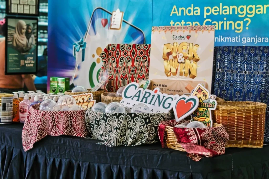 Caring Pharmacy Mural Unveiling l Kota Sentosa Kuching 6 Caring Pharmacy Kota Sentosa Kuching pick and win display with woven baskets, prize balls and festive Hari Gawai signage