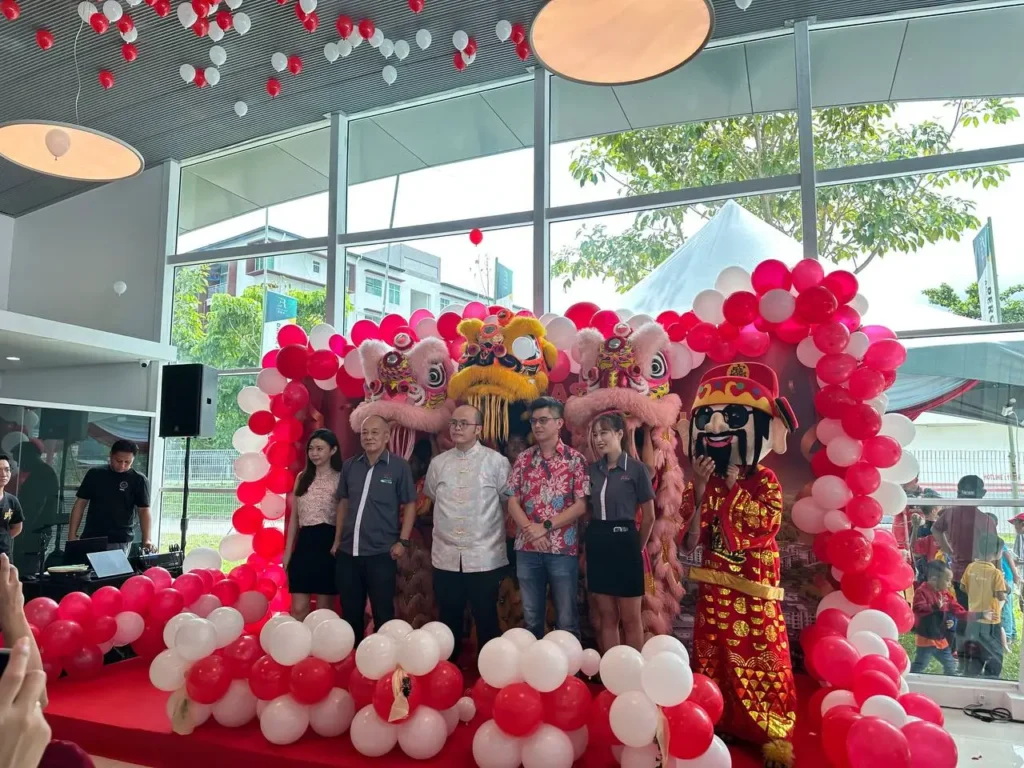 Wide shot of E Residence Phase 2B launch ceremony with red and white balloon decor