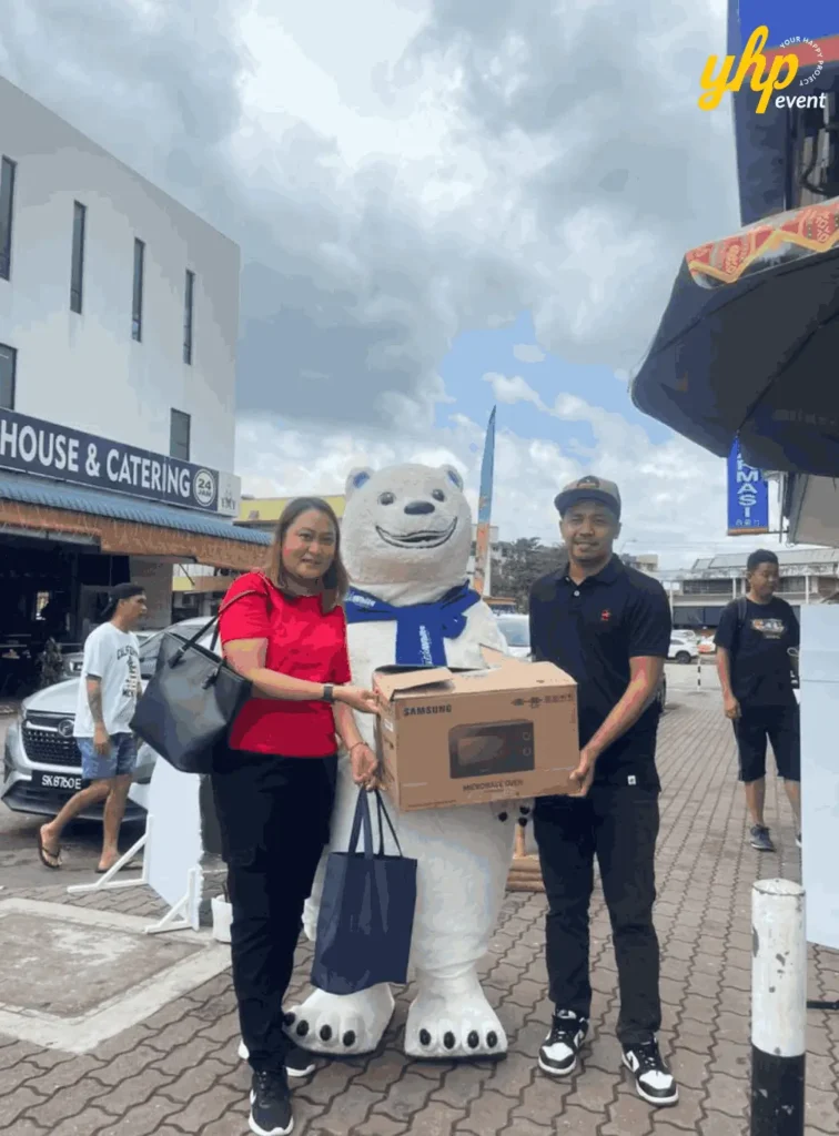 Fresh & White Borneo Edition: Out-of-Home Activation Across Sabah & Sarawak 4 Prize handover beside polar bear mascot as winners hold boxed appliance on pavement outside event booth