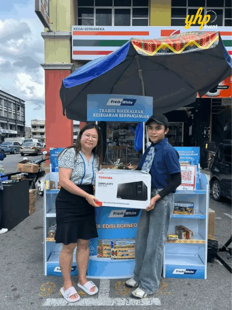 Fresh & White Borneo Edition: Out-of-Home Activation Across Sabah & Sarawak 5 Customer poses with boxed microwave and staff member at Fresh and White street booth