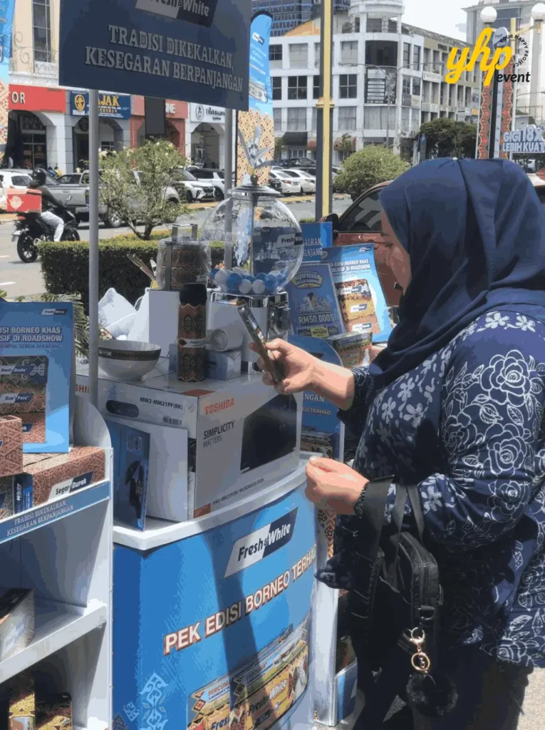 Fresh & White Borneo Edition: Out-of-Home Activation Across Sabah & Sarawak 7 Visitor draws capsule from dispenser at Fresh and White booth surrounded by product prizes