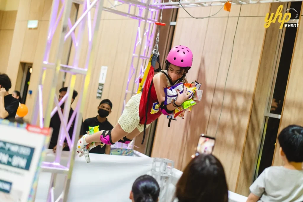 Celebrating the Grand Launch of Curve25 12 A child participates in a human claw machine game grabbing snacks