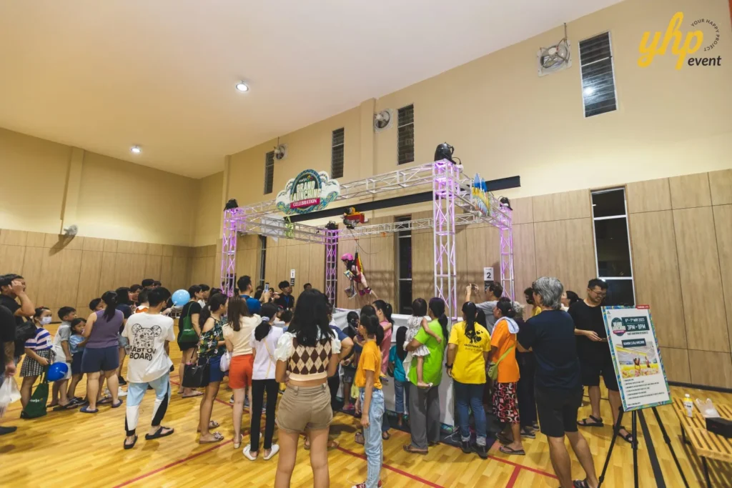 Celebrating the Grand Launch of Curve25 13 Large crowd of families gathering around the human claw machine game