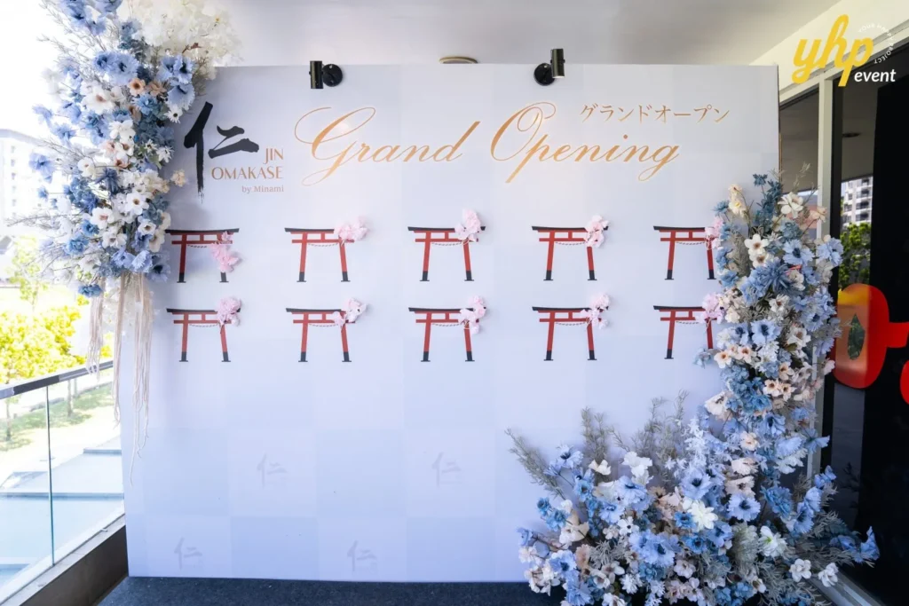 Grand Launching of JIN Omakase: A Culinary Extravaganza in Kota Kinabalu 2 Jin Omakase by Minami event backdrop with elegant gold lettering, blue flowers, and traditional Japanese gate designs