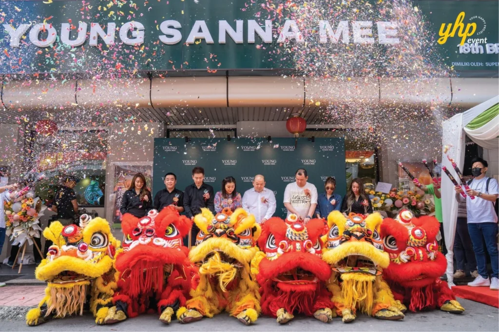 Grand Opening of Young Sanna Mee in Sabah - Enjoy Delicious and Healthy Noodles 12 Management team and lion dancers posing under falling confetti at the Young Sanna Mee grand opening