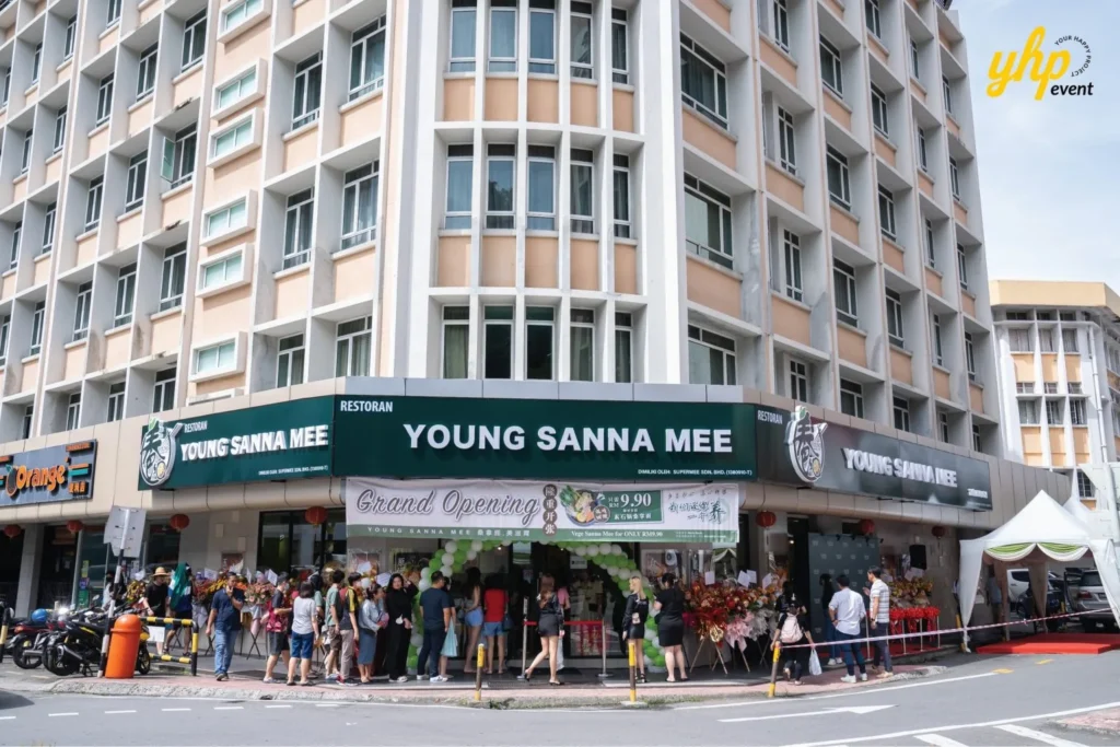 Grand Opening of Young Sanna Mee in Sabah - Enjoy Delicious and Healthy Noodles 7 Exterior corner view of the Young Sanna Mee restaurant building with flower stands and a grand opening sign