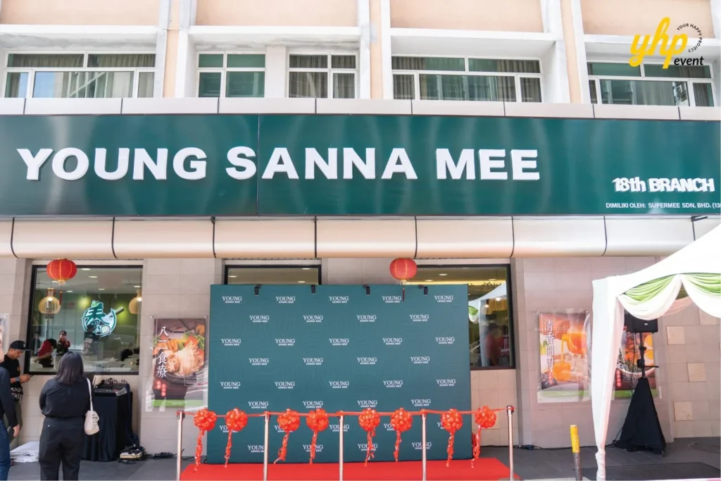 Grand Opening of Young Sanna Mee in Sabah - Enjoy Delicious and Healthy Noodles 8 Young Sanna Mee 18th branch storefront featuring a green backdrop and red ribbon for the official opening