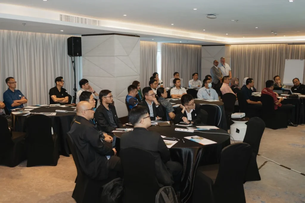 Ignite IT : Powering Tomorrow’s Solutions 3 Attendees seated at round tables listening to a business presentation during a Systemizer Technic seminar