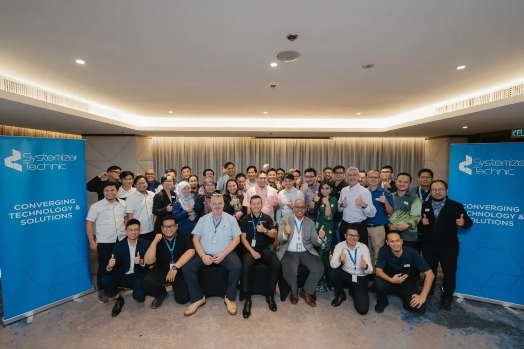 Ignite IT : Powering Tomorrow’s Solutions 7 A large group of professionals posing for a team photo at a Systemizer Technic corporate networking event