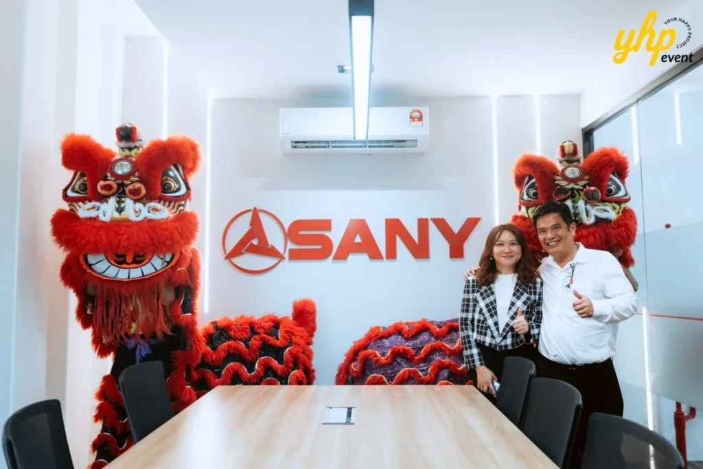 JT Machinery Office Launching 6 JT Machinery Sdn Bhd team posing in the new SANY branded conference room with lion dance heads