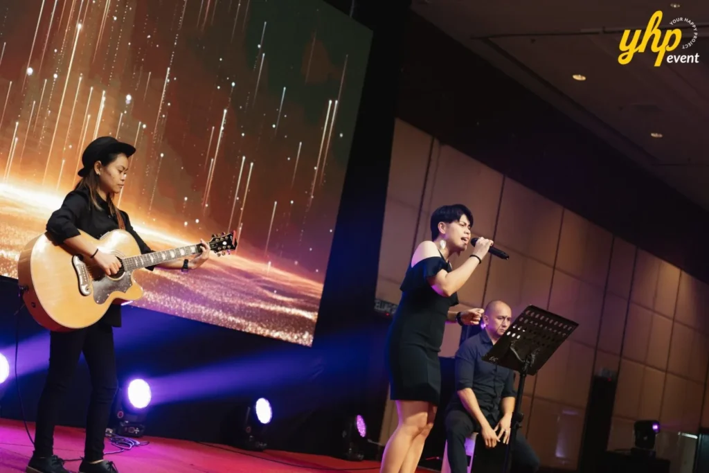 Live acoustic band with a female guitarist and singer performing on stage