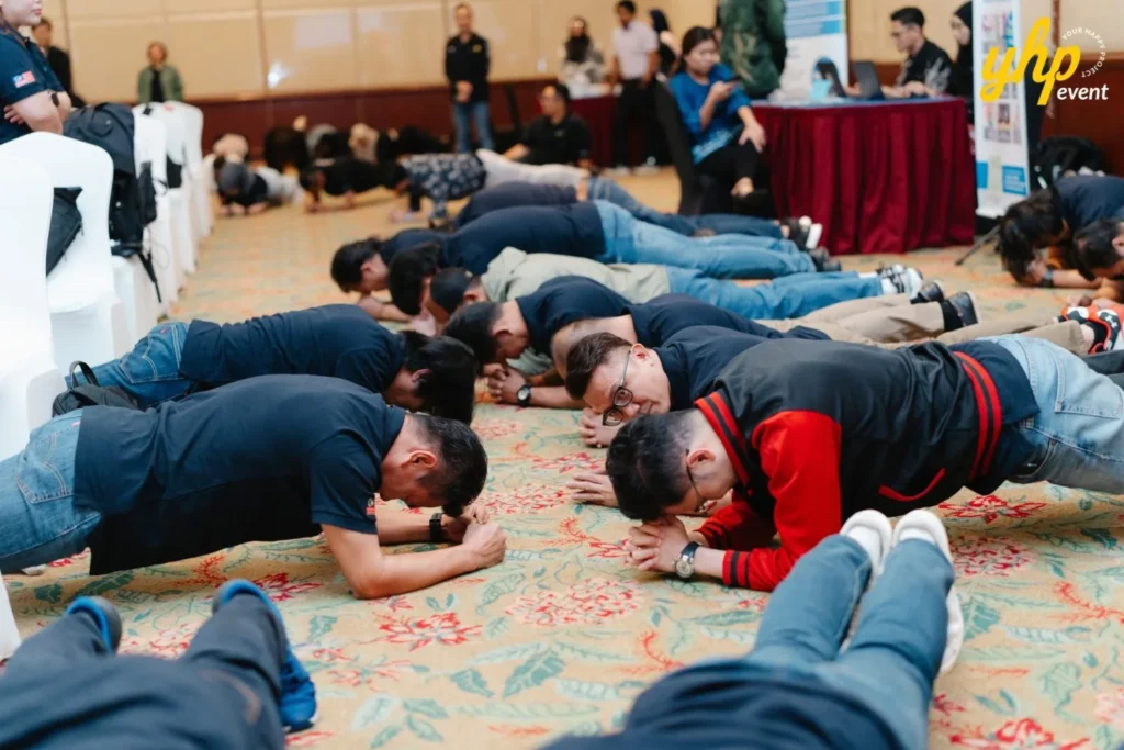 Corporate event participants performing a plank exercise challenge during an HSSE Day team activity