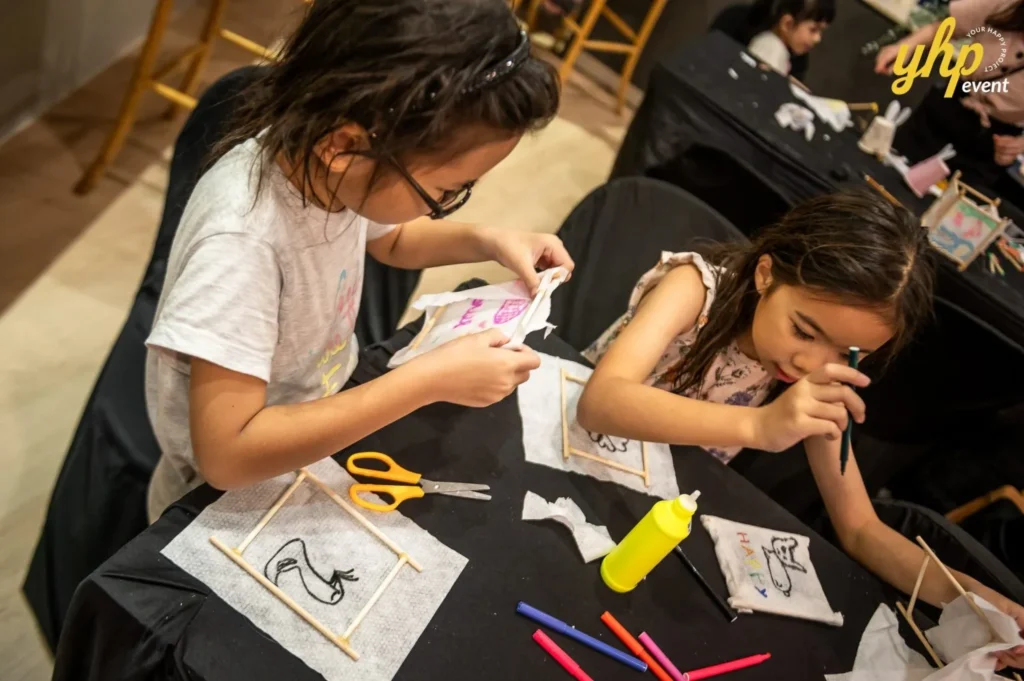 Magical Mid Autumn Gathering in Curve25 11 Children drawing and gluing paper onto frames for a Mid-Autumn Festival lantern building craft station