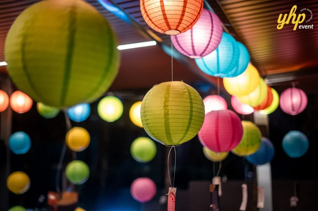 Magical Mid Autumn Gathering in Curve25 3 Close-up of glowing Mid-Autumn Festival paper lanterns in blue, orange, and green at a night celebration