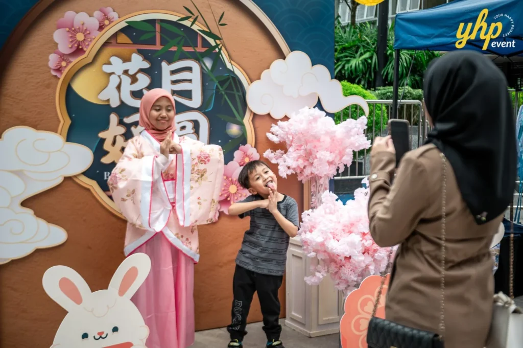 Magical Mid Autumn Gathering in Curve25 6 Young girl in traditional Hanfu posing with a boy in front of a Mid-Autumn Festival rabbit photo booth