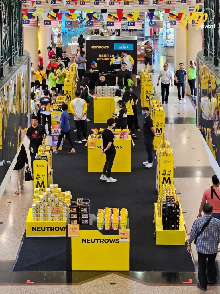 Unveiling Neutrovis: Beyond Masks, Into Complete Protection 2 A long NEUTROVIS product showcase on black carpet in a busy mall atrium decorated with country flags
