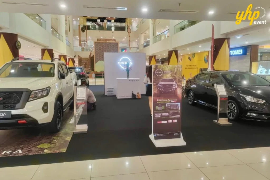 Experience Innovation and Comfort at the Nissan Roadshow 3 Nissan Navara and Almera cars on display at a shopping mall automotive roadshow with brand signage