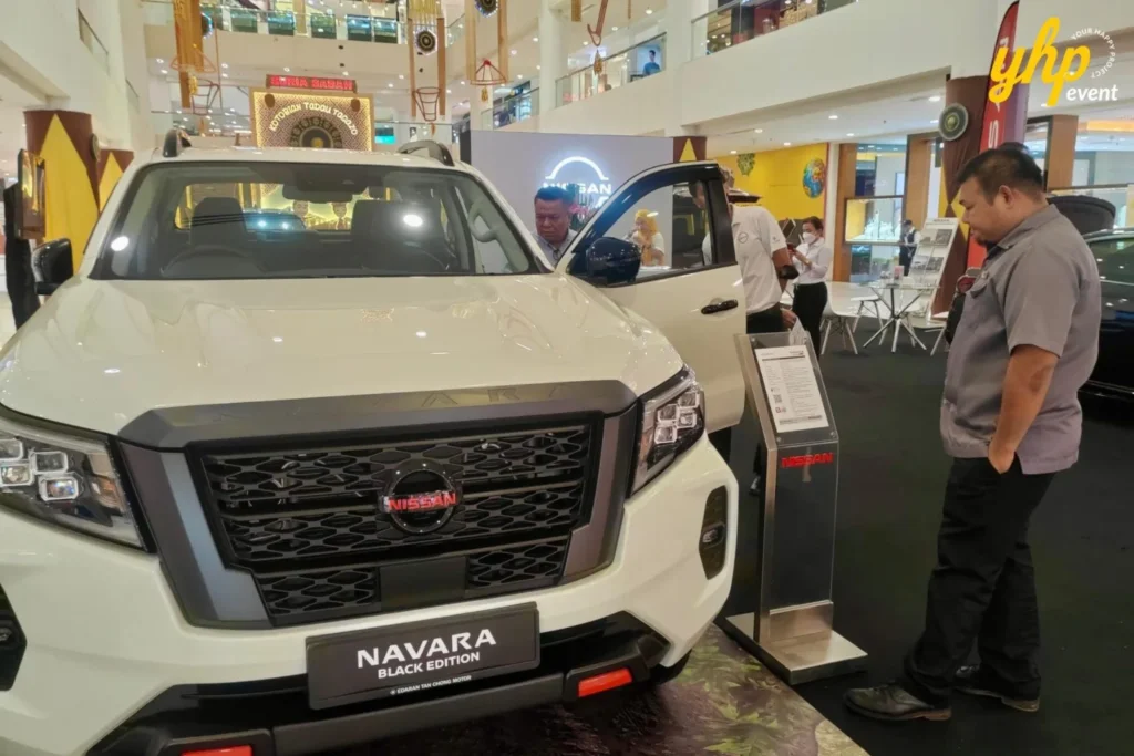 Experience Innovation and Comfort at the Nissan Roadshow 6 Front view of a Nissan Navara truck with visitors examining the exterior at a mall car exhibition