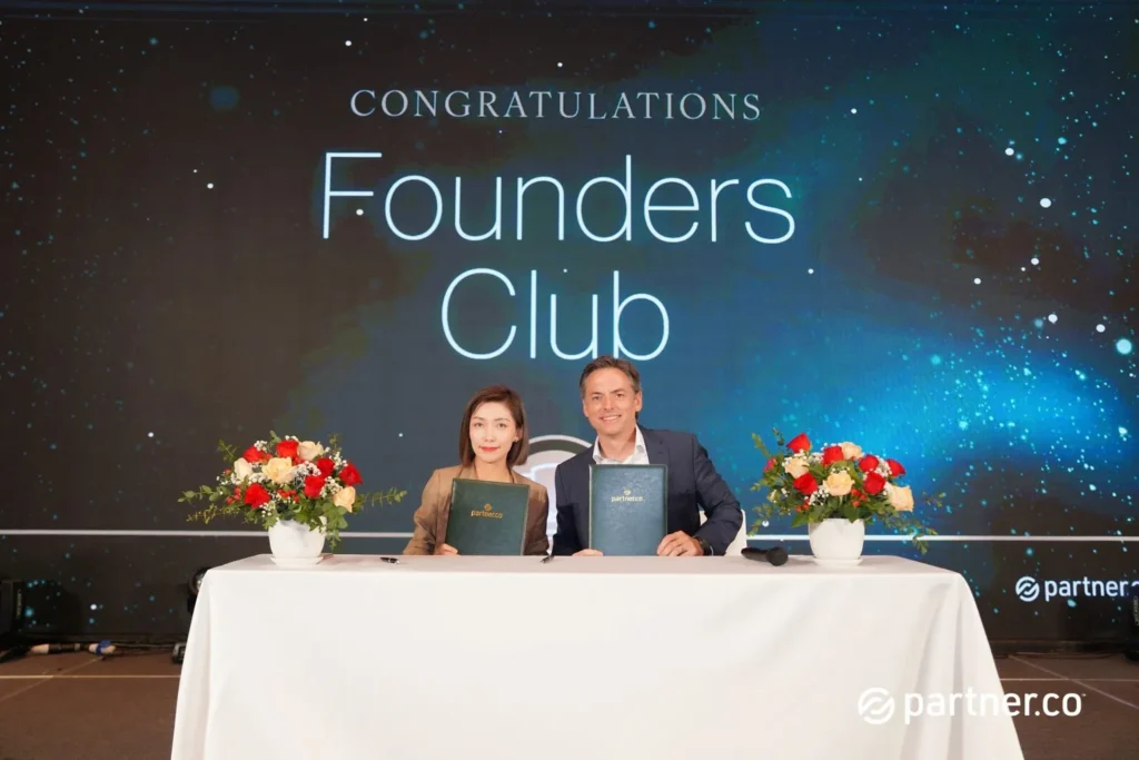 Unleashing the Future of Business: Partner.Co's Star Partner Business Conference & Award Night 11 Two business professionals holding signed green folders for the Founders Club induction at Partner.Co