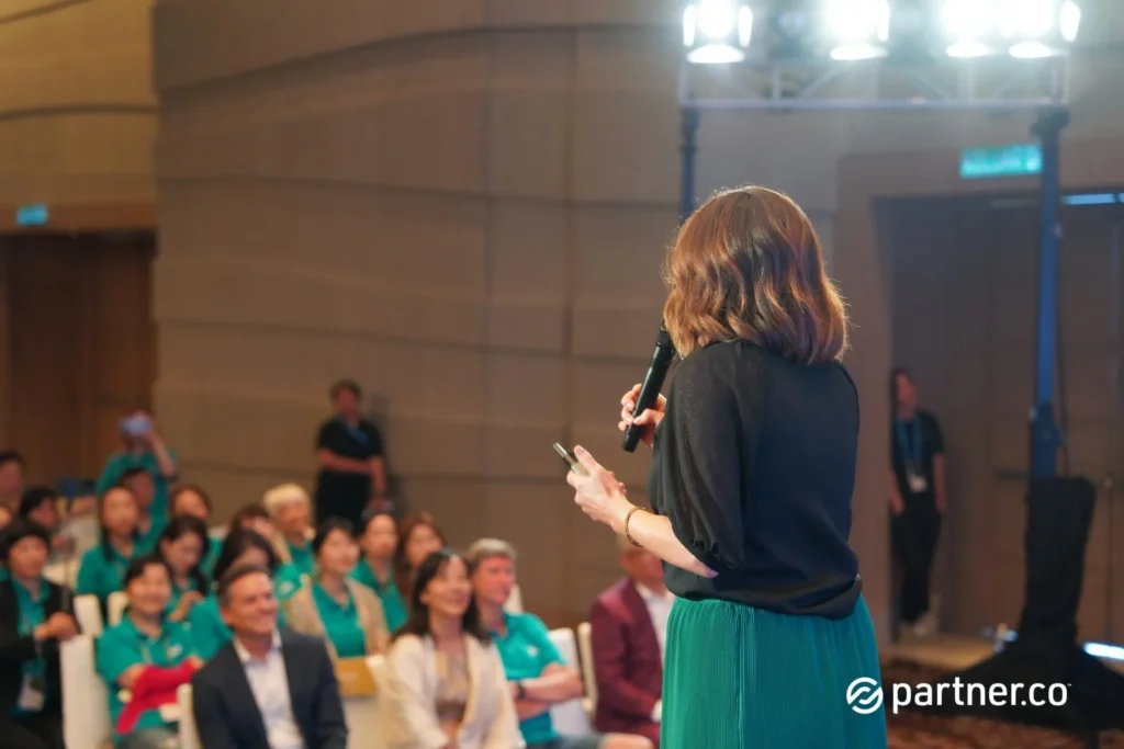 Unleashing the Future of Business: Partner.Co's Star Partner Business Conference & Award Night 6 Rear view of a female keynote speaker addressing a seated audience