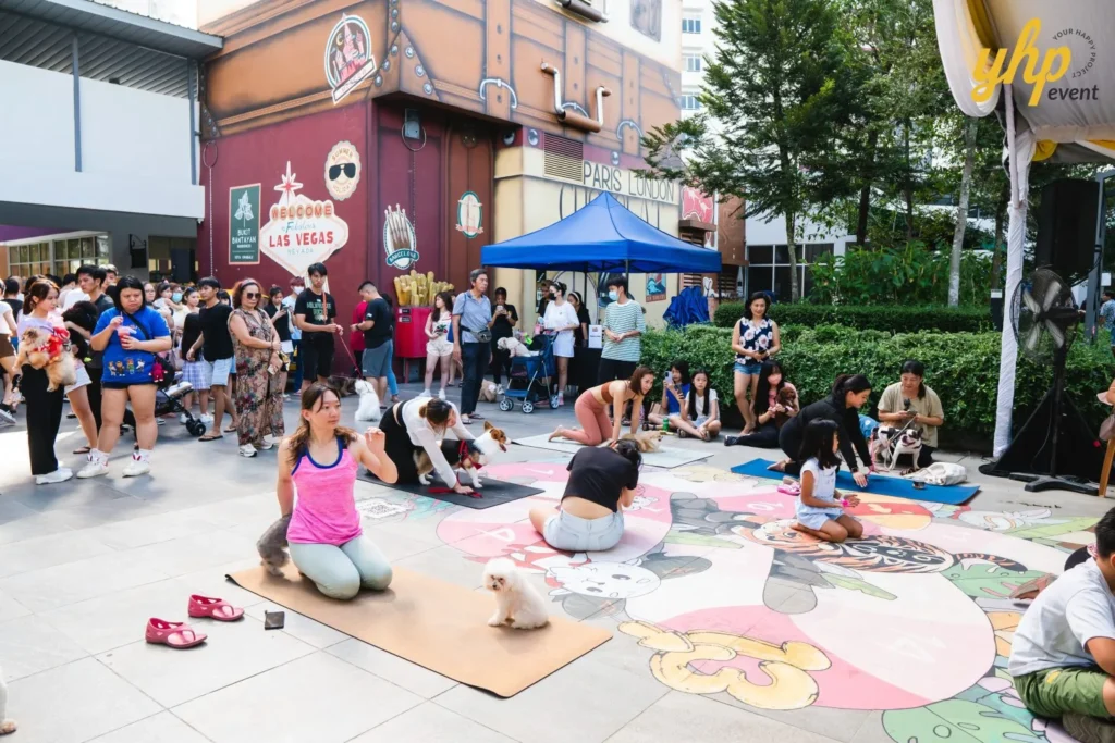 People and their dogs practicing yoga on mats over a large floor mural