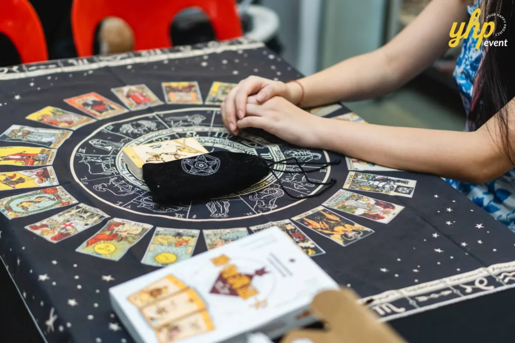Close-up of tarot cards and a zodiac mat at a pet event booth dedicated to mystical pet readings