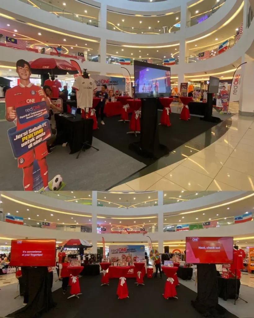 REDone Roadshow: Meet & Greet with Sabah FC (Football Club) 4 redONE Mobile branding displays and digital screens in a multi-level shopping mall atrium with flags