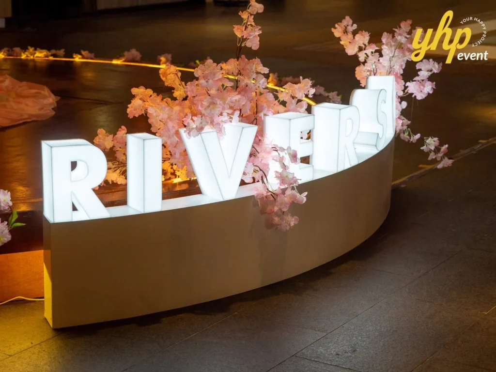 Riverson - Christmas & Lunar New Year Decoration 15 Glowing white Riverson letter signage decorated with pink cherry blossom flowers for a mall event