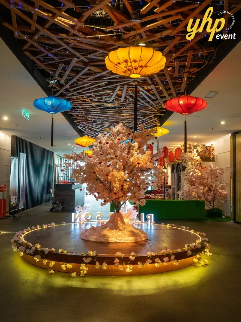 Riverson - Christmas & Lunar New Year Decoration 13 Scenic event walkway with cherry blossom tree, lighted circular stage, and hanging lanterns