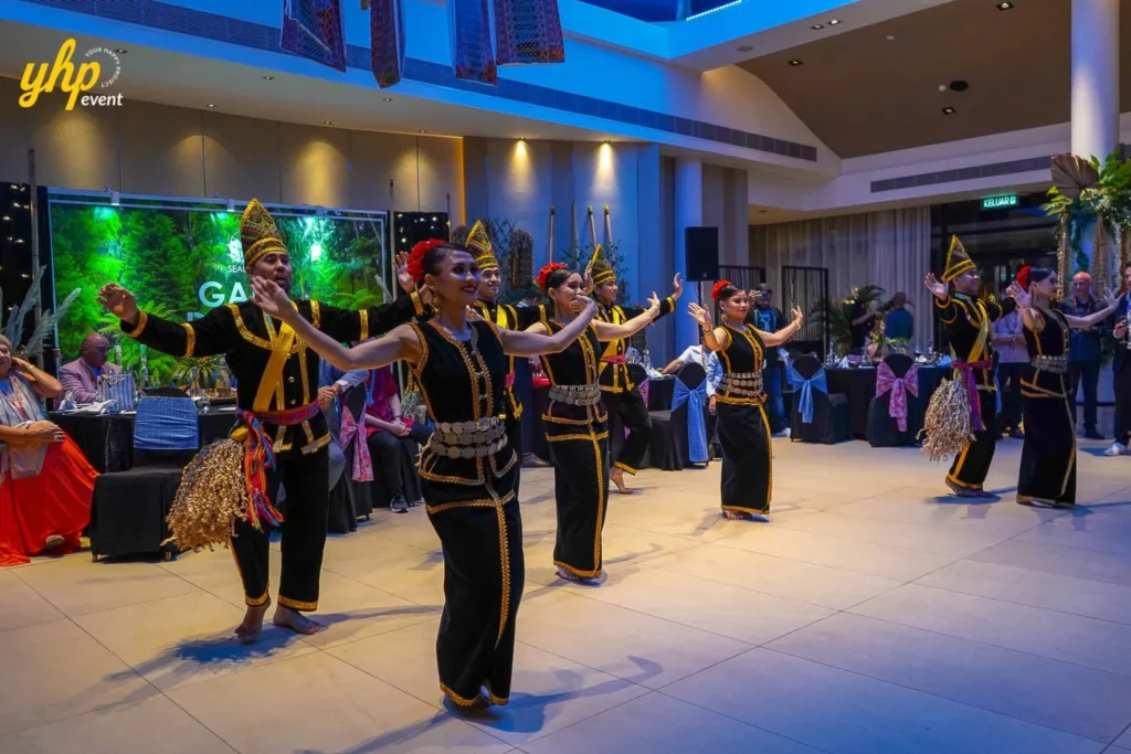 Sabah Cultural Night - Sumazau Dance Performers in traditional black and gold Sumazau costumes dancing on stage at a gala dinner event