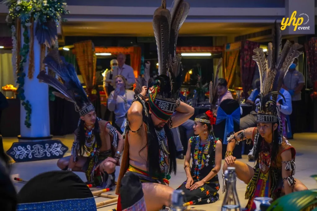 Sabah Magunatip Dance Male performers preparing their feathered headgear for a tribal warrior dance