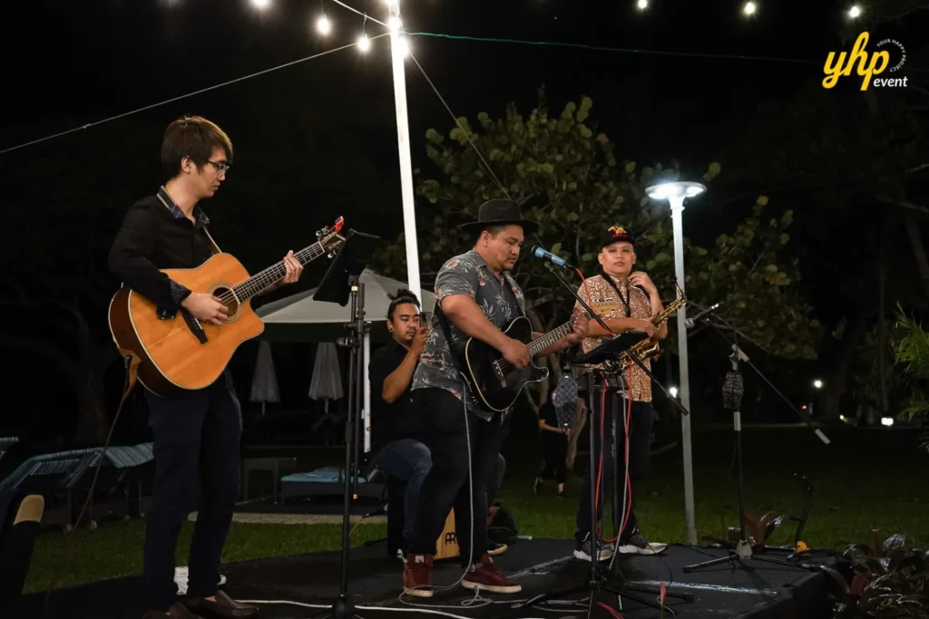 Appy Tots Live acoustic band performing on a stage with guitars and saxophone for guests at Shangrila Rasa Ria Hotel