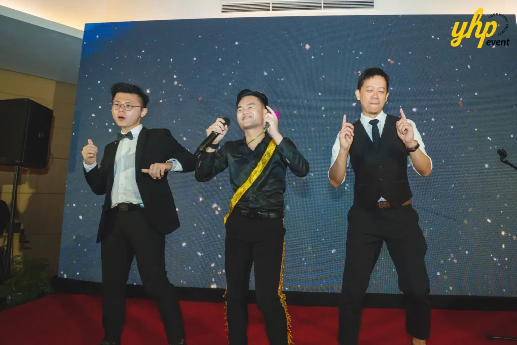 Three men performing during a corporate event at Shangri-La Tanjung Aru with vibrant stage lighting