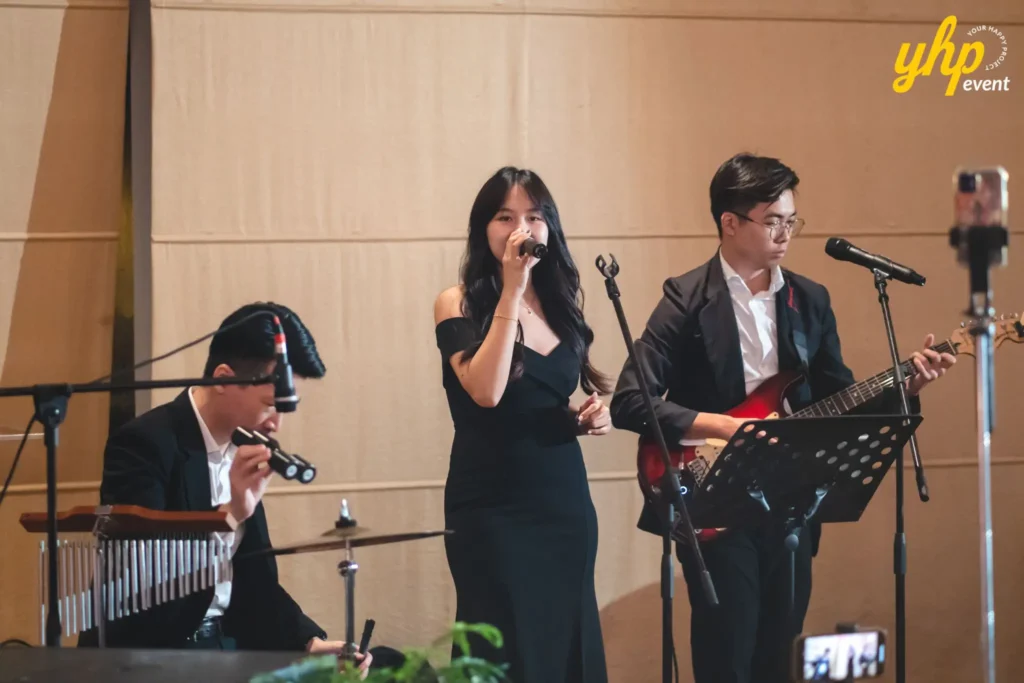 Live acoustic band performing music on stage for guests at a formal corporate gala dinner reception
