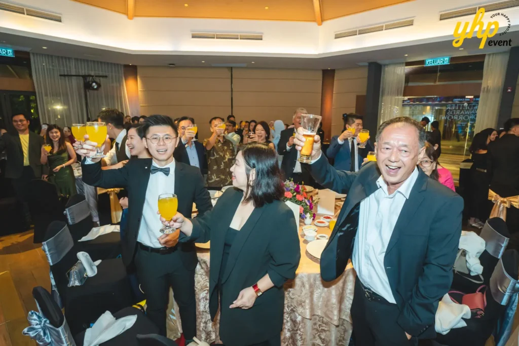 Celebratory toast at a corporate event with guests smiling and holding glasses of juice and beer