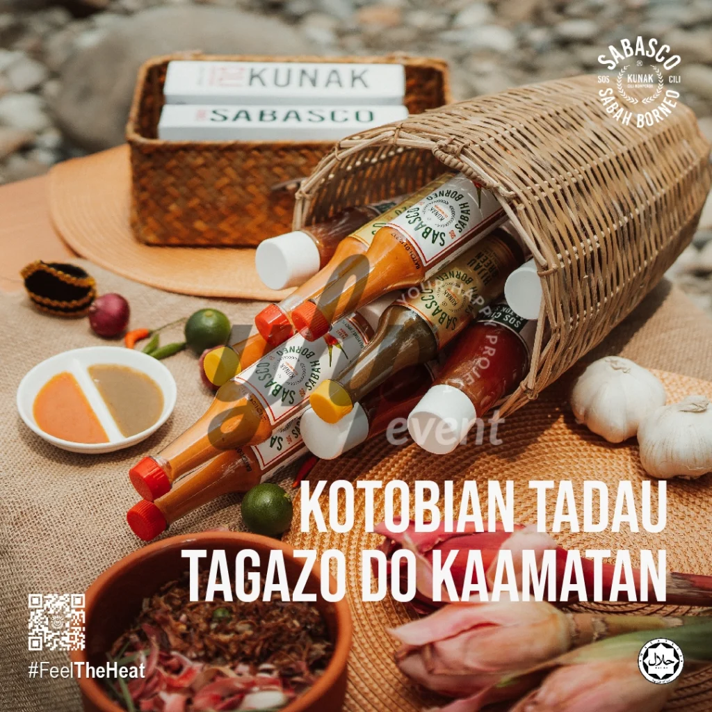 The Local Sabah Chili Sauce Brand That’s Heating Up 16 Woven basket spilling Sabasco Sabah Borneo chili sauce bottles beside garlic, limes, and Kaamatan festive food