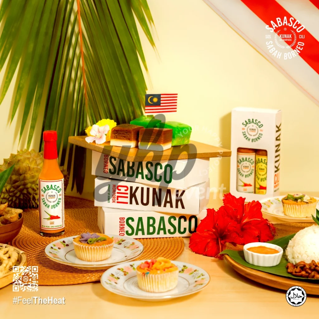 The Local Sabah Chili Sauce Brand That’s Heating Up 17 Sabasco Sabah Borneo chili sauce gift display with Malaysian flag, cakes, rice, and tropical flowers on a table