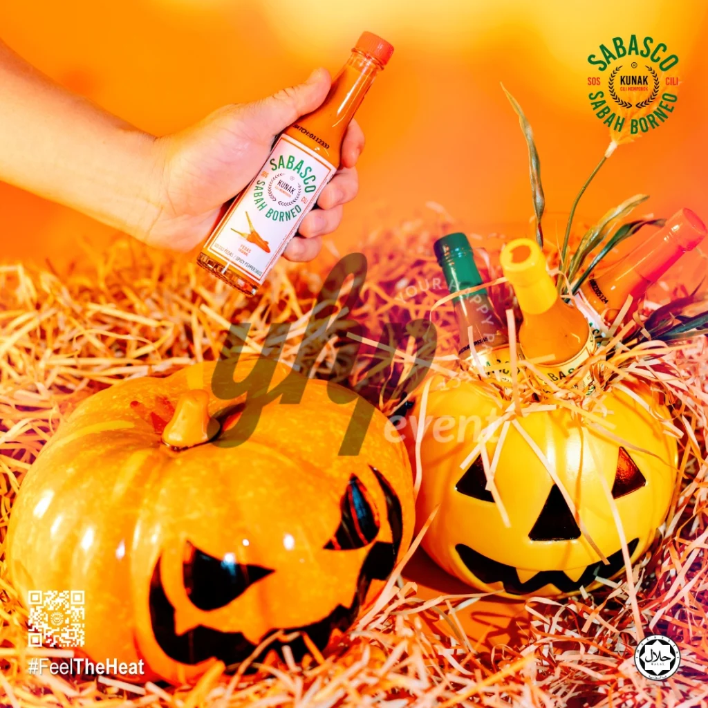 The Local Sabah Chili Sauce Brand That’s Heating Up 25 Hand holding a Sabasco Sabah Borneo chili sauce bottle above Halloween pumpkins and orange shredded decor