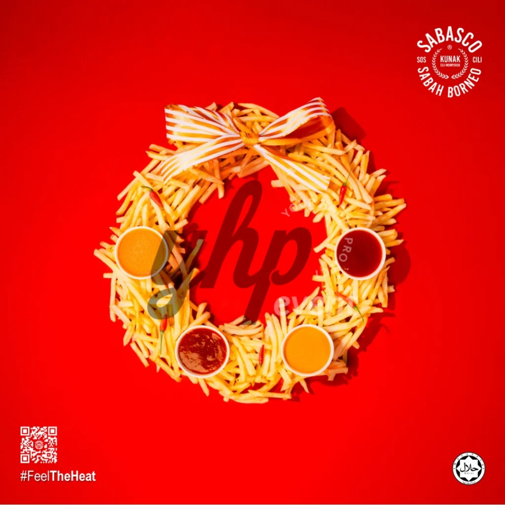 The Local Sabah Chili Sauce Brand That’s Heating Up 36 French fries shaped into a festive wreath with dipping sauces on a bright red holiday-themed background