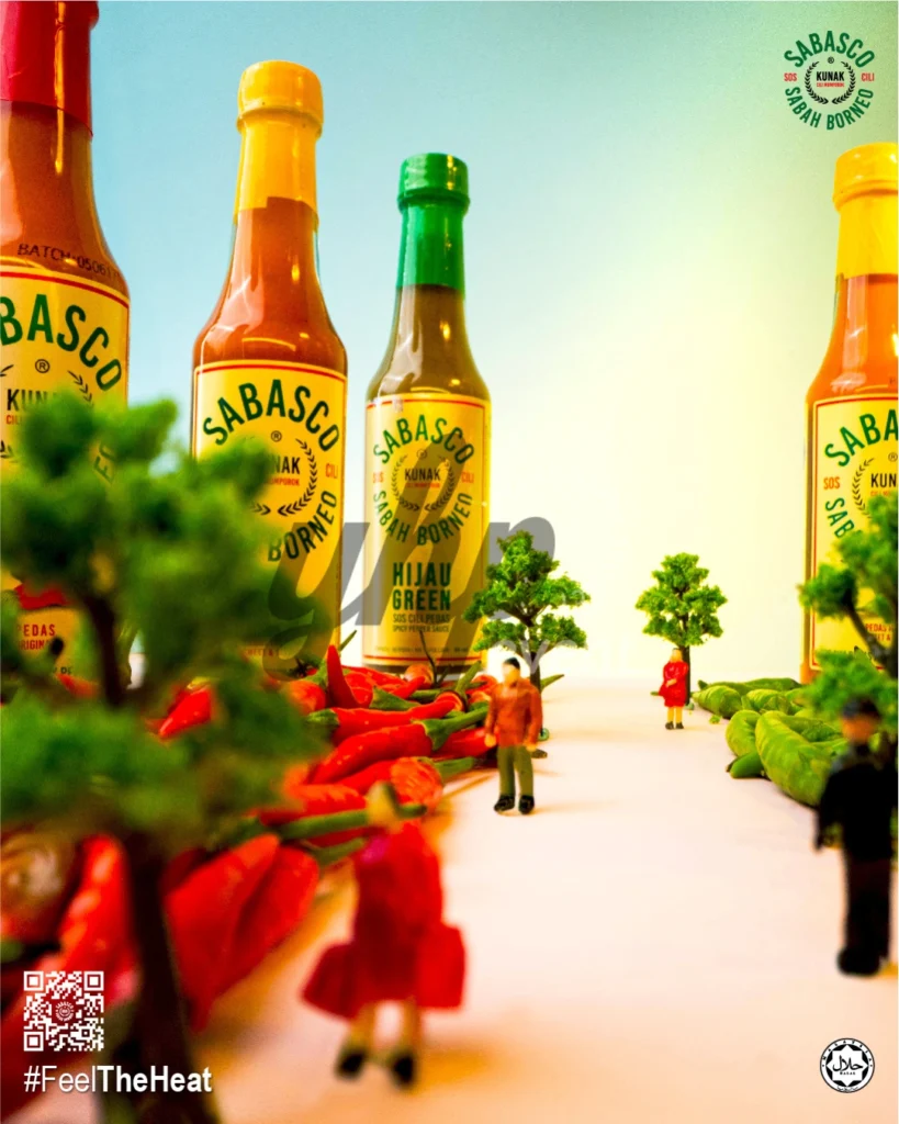 The Local Sabah Chili Sauce Brand That’s Heating Up 40 Miniature landscape scene with towering Sabasco Sabah Borneo chili sauce bottles, trees, and tiny human figures