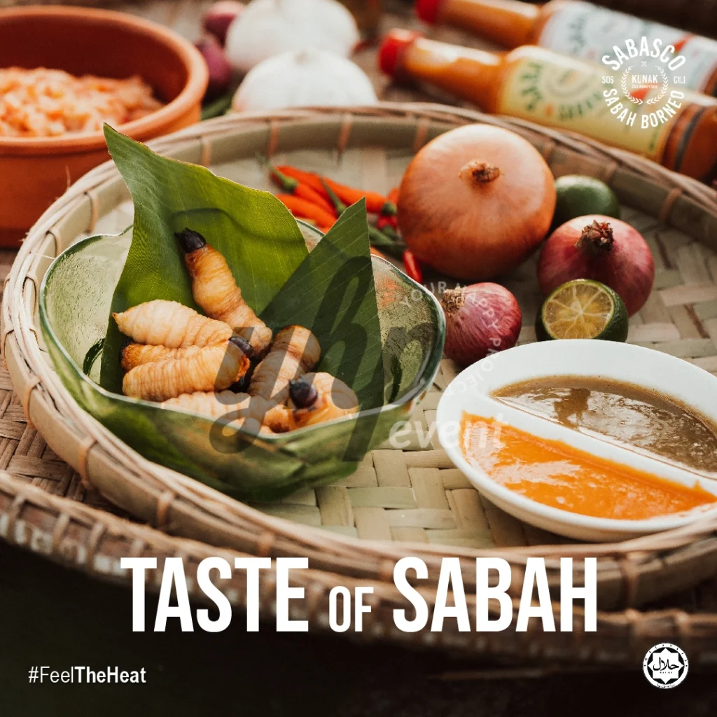 The Local Sabah Chili Sauce Brand That’s Heating Up 13 Bowl of sago grubs on banana leaf beside dipping sauces, onions, and Sabasco Sabah Borneo chili sauce bottles