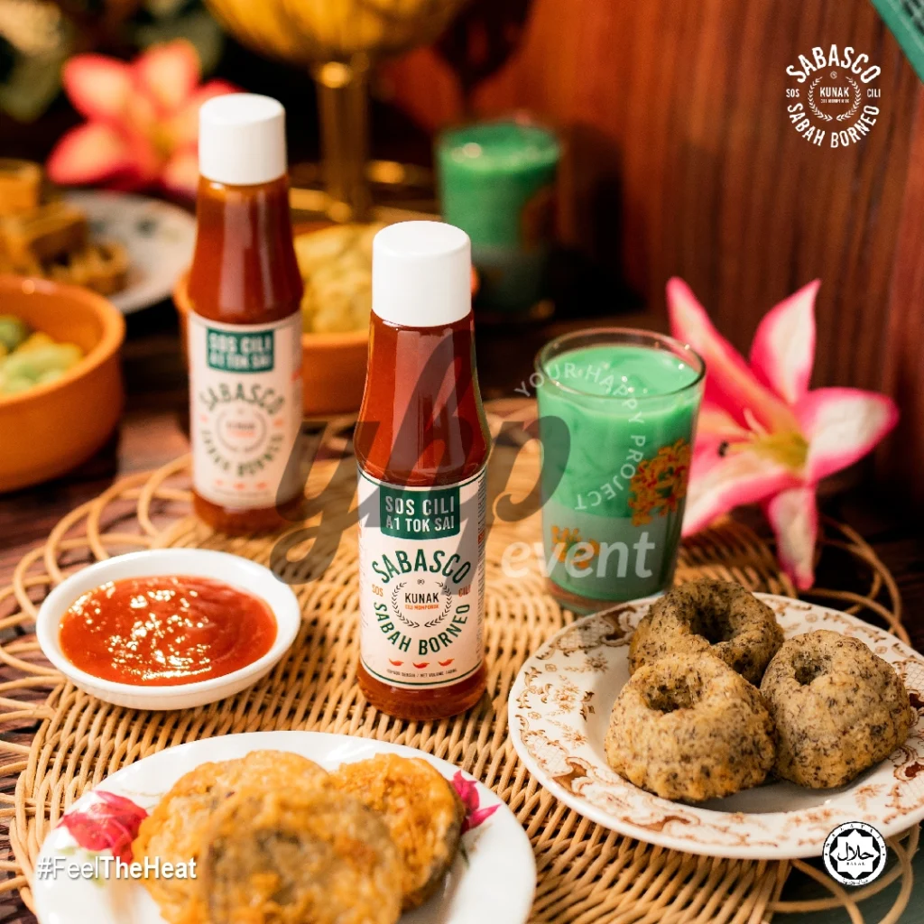 The Local Sabah Chili Sauce Brand That’s Heating Up 6 Sabasco Sabah Borneo chili sauce bottles on a dining table with dipping sauce, kuih, and traditional snacks